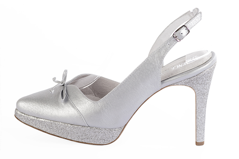 Light silver women's open back shoes, with a knot. Tapered toe. Very high slim heel with a platform at the front. Profile view - Florence KOOIJMAN